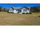 Beautiful white home with blue shutters set on a vast lawn, perfect for outdoor activities at 8524 Cane Branch Rd, Ruffin, SC 29475