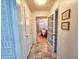 Hallway featuring tiled floors, storage closets, and a glimpse into the dining room and living room at 8524 Cane Branch Rd, Ruffin, SC 29475