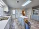 Functional kitchen with blue cabinets, white appliances, island counter, and checkered flooring at 8524 Cane Branch Rd, Ruffin, SC 29475