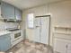 A kitchen featuring a white refrigerator, white stove, window, and light blue cabinets and drawers at 8524 Cane Branch Rd, Ruffin, SC 29475