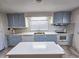 A kitchen featuring an island, window, white appliances, and light blue cabinets and drawers at 8524 Cane Branch Rd, Ruffin, SC 29475