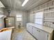 Utility room with water heater, shelves, window, cabinets, and utility sink at 8524 Cane Branch Rd, Ruffin, SC 29475