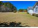 Spacious yard showing the side of a white home surrounded by trees at 8524 Cane Branch Rd, Ruffin, SC 29475