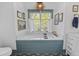Bright bathroom featuring a soaking tub with a window view and blue wood paneling at 10044 Randall Rd, McClellanville, SC 29458