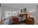 Comfortable bedroom with a large bed, soft lighting, hardwood floors and large windows at 10044 Randall Rd, McClellanville, SC 29458