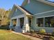 Inviting home exterior showcases a charming covered porch, lush landscaping, and a well-manicured lawn at 10044 Randall Rd, McClellanville, SC 29458