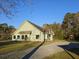 Light-green exterior with a gravel driveway and large front yard at 10044 Randall Rd, McClellanville, SC 29458