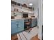 Office nook with custom blue cabinets, butcher block countertops, open shelving, and hardwood floors at 10044 Randall Rd, McClellanville, SC 29458