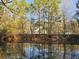 Scenic view of home reflected in the calm waters of the pond, surrounded by lush greenery at 10044 Randall Rd, McClellanville, SC 29458