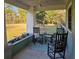 Cozy front porch with rocking chairs offering serene views of the expansive front yard and landscaping at 10044 Randall Rd, McClellanville, SC 29458