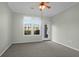 Bright bedroom featuring neutral carpeting, a ceiling fan, and a large window offering outside views at 1012 Rosewood Ln, Mount Pleasant, SC 29464