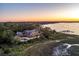 Spectacular aerial view of an expansive waterfront estate with a pool, dock, and panoramic sunset backdrop at 108 Salthouse Ln, Kiawah Island, SC 29455