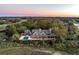 Stunning aerial view of a grand estate with a pool, sprawling grounds, and views of the golf course and adjacent waterway at 108 Salthouse Ln, Kiawah Island, SC 29455