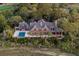 Aerial view of a spacious home featuring a pool, outdoor dining area, and luxurious deck space nestled amongst palm trees at 108 Salthouse Ln, Kiawah Island, SC 29455