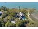 An aerial view of the waterfront estate shows a private dock, lush landscaping, and stunning water views at 108 Salthouse Ln, Kiawah Island, SC 29455