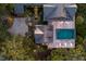 Overhead view of a stylish home with pool, patio, lush grounds, circular drive, and meticulous landscaping with outdoor lighting at 108 Salthouse Ln, Kiawah Island, SC 29455