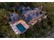 Expansive home features a pool and outdoor seating with mature landscaping, an attached outdoor kitchen, and lighting at 108 Salthouse Ln, Kiawah Island, SC 29455