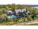 An aerial view showcases the waterfront estate, lush landscaping, a private dock, and outdoor pool at 108 Salthouse Ln, Kiawah Island, SC 29455