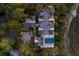 Overhead view of a stylish home with pool, patio, lush grounds, circular drive, and meticulous landscaping with outdoor lighting at 108 Salthouse Ln, Kiawah Island, SC 29455