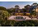 A large patio and pool area with dining and lounging, surrounded by mature landscaping and a partial view of the main house at 108 Salthouse Ln, Kiawah Island, SC 29455