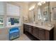 Bright bathroom featuring double vanity, granite counters, and natural light from a window at 108 Salthouse Ln, Kiawah Island, SC 29455