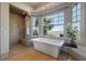 Bright bathroom featuring a modern soaking tub, glass-enclosed shower, and large windows with scenic views at 108 Salthouse Ln, Kiawah Island, SC 29455