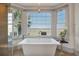 Serene bathroom featuring a soaking tub with scenic waterfront views and a charming bay window at 108 Salthouse Ln, Kiawah Island, SC 29455
