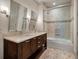 Bright bathroom features a double vanity with stone countertop, tiled shower, and stylish fixtures at 108 Salthouse Ln, Kiawah Island, SC 29455