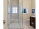 Shower with glass door, seat, tile surround, plus sink and window at 108 Salthouse Ln, Kiawah Island, SC 29455