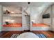 Unique bunk room with four built-in twin beds featuring orange patterned bedding, a ladder, and hardwood floors at 108 Salthouse Ln, Kiawah Island, SC 29455