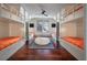 Unique bunk room with four built-in twin beds featuring orange patterned bedding and hardwood floors at 108 Salthouse Ln, Kiawah Island, SC 29455