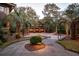 Expansive driveway leads to a three-car garage, enhanced by mature trees and meticulous landscaping at 108 Salthouse Ln, Kiawah Island, SC 29455