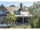 An exterior view of the home shows multiple stories, outdoor living spaces, and lush landscaping at 108 Salthouse Ln, Kiawah Island, SC 29455
