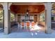 A covered outdoor kitchen features stainless steel appliances, granite countertops, and seating for outdoor dining at 108 Salthouse Ln, Kiawah Island, SC 29455