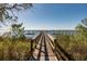 Beautiful view of the serene ocean from the wooden pier featuring lush greenery on either side at 108 Salthouse Ln, Kiawah Island, SC 29455