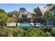 The private pool is surrounded by lush landscaping, an outdoor kitchen, and comfortable lounge chairs at 108 Salthouse Ln, Kiawah Island, SC 29455