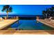 Infinity pool at dusk with scenic views of the water and lush surroundings, creating a tranquil ambiance at 108 Salthouse Ln, Kiawah Island, SC 29455