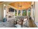 Inviting covered porch features a fireplace, TV, and comfortable seating with beautiful natural views at 108 Salthouse Ln, Kiawah Island, SC 29455