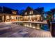 Beautiful rear exterior view of the home featuring a pool, deck with lounge chairs, and landscaped grounds at twilight at 108 Salthouse Ln, Kiawah Island, SC 29455