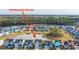 Aerial view of the neighborhood, highlighting the pond, trees, and colorful houses at 1081 Magnolia Warbler Way, Ravenel, SC 29470