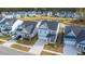 Aerial view of a neighborhood with colorful houses and a central pond at 1081 Magnolia Warbler Way, Ravenel, SC 29470