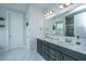 Elegant bathroom featuring double vanity sinks, marble tile, and modern fixtures at 1081 Magnolia Warbler Way, Ravenel, SC 29470