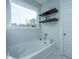 Bright bathroom featuring a soaking tub, floating shelves and a large window at 1081 Magnolia Warbler Way, Ravenel, SC 29470