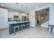 An open-concept kitchen with white cabinets, stainless steel appliances, and a large island with barstool seating at 1081 Magnolia Warbler Way, Ravenel, SC 29470