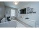 Cozy living area with a comfortable sofa, mounted TV, and stylish storage at 1081 Magnolia Warbler Way, Ravenel, SC 29470