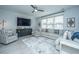 Cozy living room with comfortable seating, a modern ceiling fan, and large windows for natural light at 1081 Magnolia Warbler Way, Ravenel, SC 29470