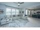 A spacious living area with a large sectional sofa, decorative rug, and view into the modern kitchen at 1081 Magnolia Warbler Way, Ravenel, SC 29470