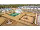 Aerial view of neighborhood playground and two pickleball courts with nearby homes at 1081 Magnolia Warbler Way, Ravenel, SC 29470