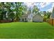 Expansive backyard featuring a lush lawn, privacy fence, and charming rear exterior of the house at 110 Cypress St, Summerville, SC 29483