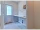 Functional laundry room with tile floors, utility sink, door to outside, and ample counter space at 110 Cypress St, Summerville, SC 29483